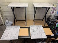 Front view of 4 TV dinner trays with white marble-look tops and black folding metal legs. Light wood-colored trays underneath are visible.
