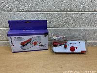 Photo of the Singer Stitch Sew Quick handheld cordless mini sewing machine with box and accessories displayed.