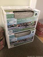 Two unopened boxes of Suncast Border Stone Edging stacked, showing front and top with branding and product info