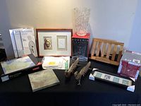 Overview of all lots showing reflexology insoles, framed art, brass peacocks, wooden rack, boxed tile/coaster set, Bohemia vase