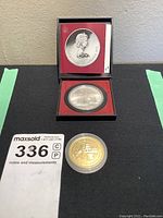 Collector coins in box and cases showing Montreal Olympic and Kingston Hockey Centennial coins.