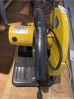 Photo depicts top handle and part of the base with the yellow motor housing and attached cord.