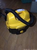 Front angle showing yellow and black body, attached black hose, and power cord sleeve.