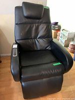 Front view of black faux leather recliner with headrest cushion and padded armrests