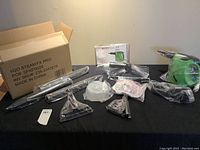 Photo of all accessories laid out on table next to main unit and user manual