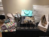 Lot overview showing pillows, wolf blanket, Aldo heels, wallets, towel hanger, and organization bags