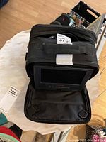Portable DVD player inside black nylon carrying case with screen and control buttons