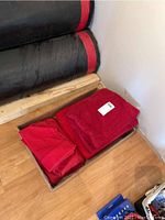 Full view of the packed red towel set in a brown box, showing folded plush bath towel and hand towels.