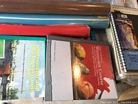 Top view of art books and large assorted paper rolls and sheets