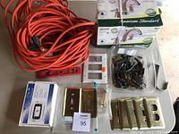 Photo showing faucet box kits, thermostat box, electrical cord, switch plates, and container of assorted hardware