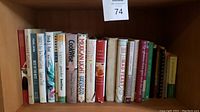 Shelf shot of about 20 cookbooks with different titles and conditions, including Mexican Light, CookWise, Lidia's Italian-American Kitchen.