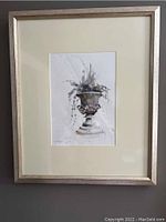Full view of the framed watercolor painting depicting an ornamental urn with foliage by Suzy Schultz, showing condition and frame.