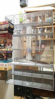 Two large vertical metal mesh racks for VHS tape storage with a stack of VHS tapes on the side.