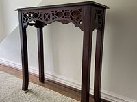 Front view of the Bombay Company console table showing carved front decoration and curved legs.