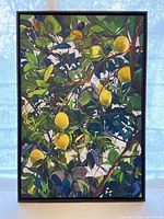 Full view of framed lemon painting with vibrant yellow lemons and green leaves.