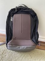 Full frontal view of the black MEC backpack showing overall shape and front padded panel with some wear and dirt visible at bottom.