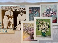 Top view of six prints displayed with the Metropolitan Museum of Art New York bag. Prints include floral artwork and vintage baseball photographs in black and white.