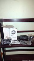 Photo showing Dash Cam Pro box, suction cup mount, cables, and accessories on a wooden surface.