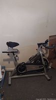 Side view of Spin Fitness spin bike showing seat, handlebar, and frame