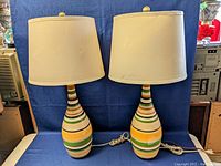 Pair of vintage ceramic table lamps with striped bases and cream lampshades