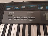 Close-up of Casio CTK-2550 keyboard control panel showing keys, volume, rhythm and song bank controls, and speaker grille.