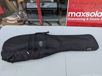 Front view of black Fender soft guitar case with zippered accessory pouch and handles.