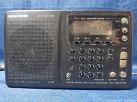 Front view of Grundig Yacht Boy 400 radio showing speaker, buttons, and digital display.