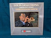 Front cover of the vinyl album showing Louis Armstrong playing trumpet, with album title and decoration.