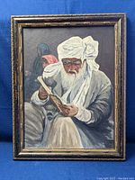 Framed original painting showing Indian man reading, well lit from front