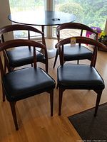 Four chairs arranged around a round table near windows, showing overall lot