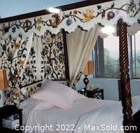 Front view of full size carved wood canopy bed with embroidered valance and drapes assembled with bedding