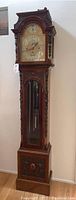 Full front view of carved wood grandfather clock