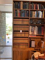 Front view of a wooden bookshelf loaded with leather-bound Scott volumes and other hardcovers