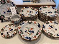 Full set of Mason's Ironstone China including various plates, bowls, saucers, and sugar bowl arranged on a table.