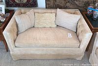 Front view of loveseat showing overall condition, upholstery and pillows