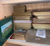 Stacked vintage coasters and photo albums on shelf, showing varied sizes and designs