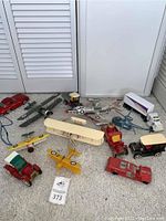 Overview of the lot showing all vintage toy planes and cars arranged on a carpeted floor, giving a clear view of each item and their condition.