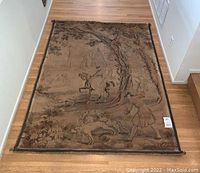 Full front view of tapestry laid flat on hardwood floor
