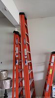 Full view of the Werner ladder folded as A-frame showing orange rails and aluminum steps