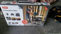 Box front view showing Keter folding work table usage and features including holding capacity