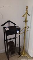 Black wooden valet stand with drawer and metal slats for storage, showing three clear acrylic CD holders and two small stands on bottom shelf.