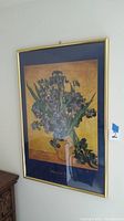 Full view of framed Van Gogh picture titled 'Frises in Vase' with golden frame and blue matting.