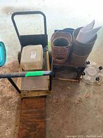 Overview of metal cart with some planter pots and plastic items on and around it