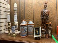 Full group showing candlesticks, canisters, wood soldier, decorative bottles, and picture frame