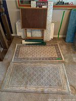 Photo of two rectangular throw rugs laid on floor, showing pattern and condition.