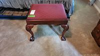 Top view of the square wooden framed stool with upholstered red diamond pattern top and carved ball and claw feet.