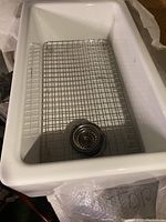Full view of sink basin with protective grid and drain strainer