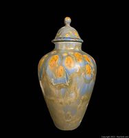 Full view of glazed ceramic urn with blue and amber glaze and matching lid with knob