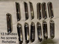 13 oblong polished nickel cup style cabinet pull handles arranged in two groups, showing front views and some side profiles.