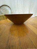 Side view of the vintage Danish Digsmed teak wooden bowl showing its conical shape and medium brown wood grain